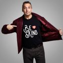 Joe Gatto from Impractical Jokers pointing at his Be Kind shirt