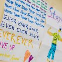 A kids artwork that reads "Never Give Up" over and over again