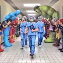 Superheroes bowing in reverence to Doctors and Nurses as they walk down a hallway