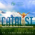 Woman in a green field raising her hands up to a blue & cloudy sky. Words read: "Catalyst Health, Wellness & Performance"